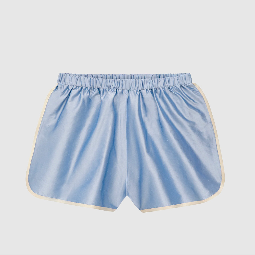 Blue taffeta track shorts with white piping.