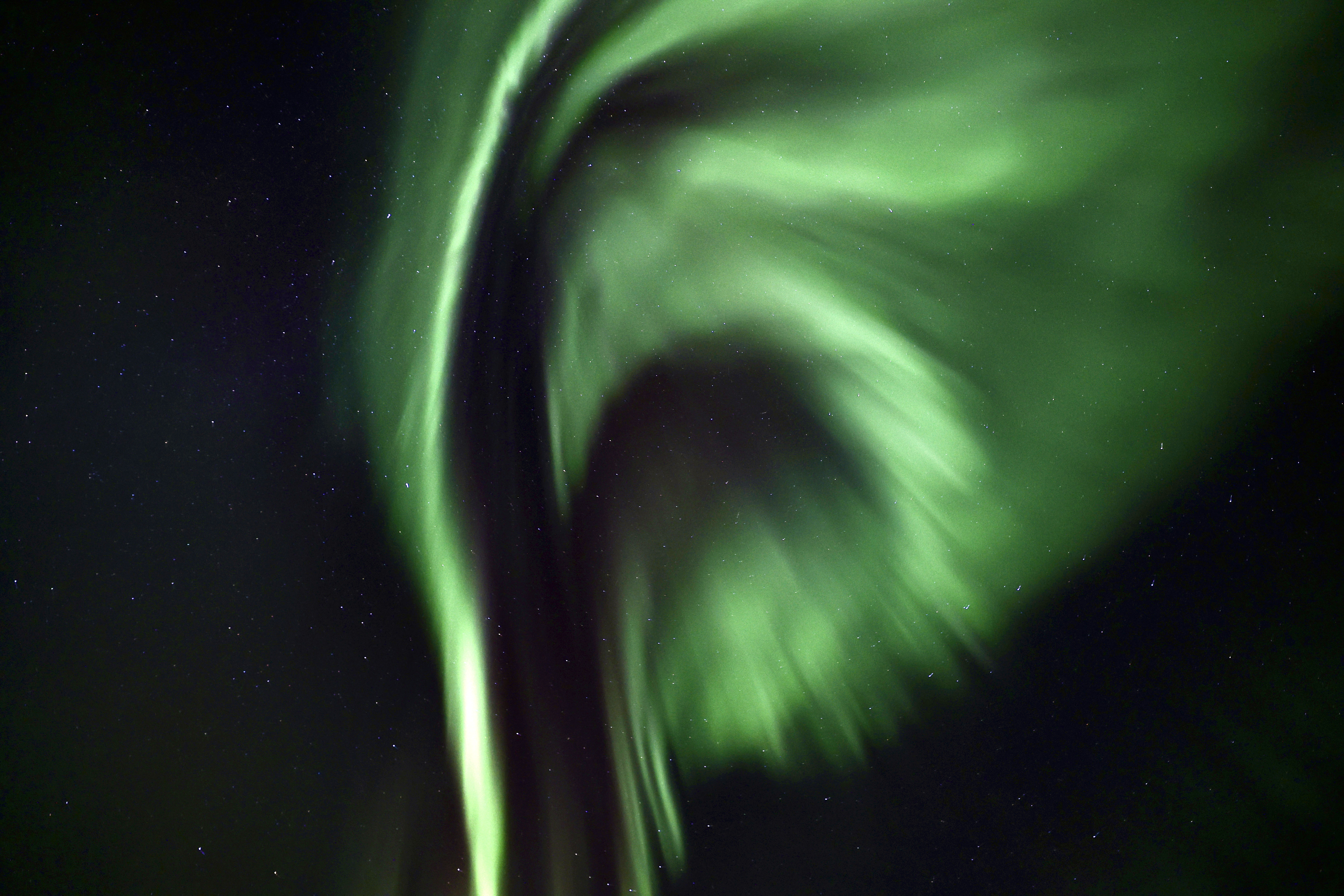 sweeping green northern lights appear as ribbons in the sky