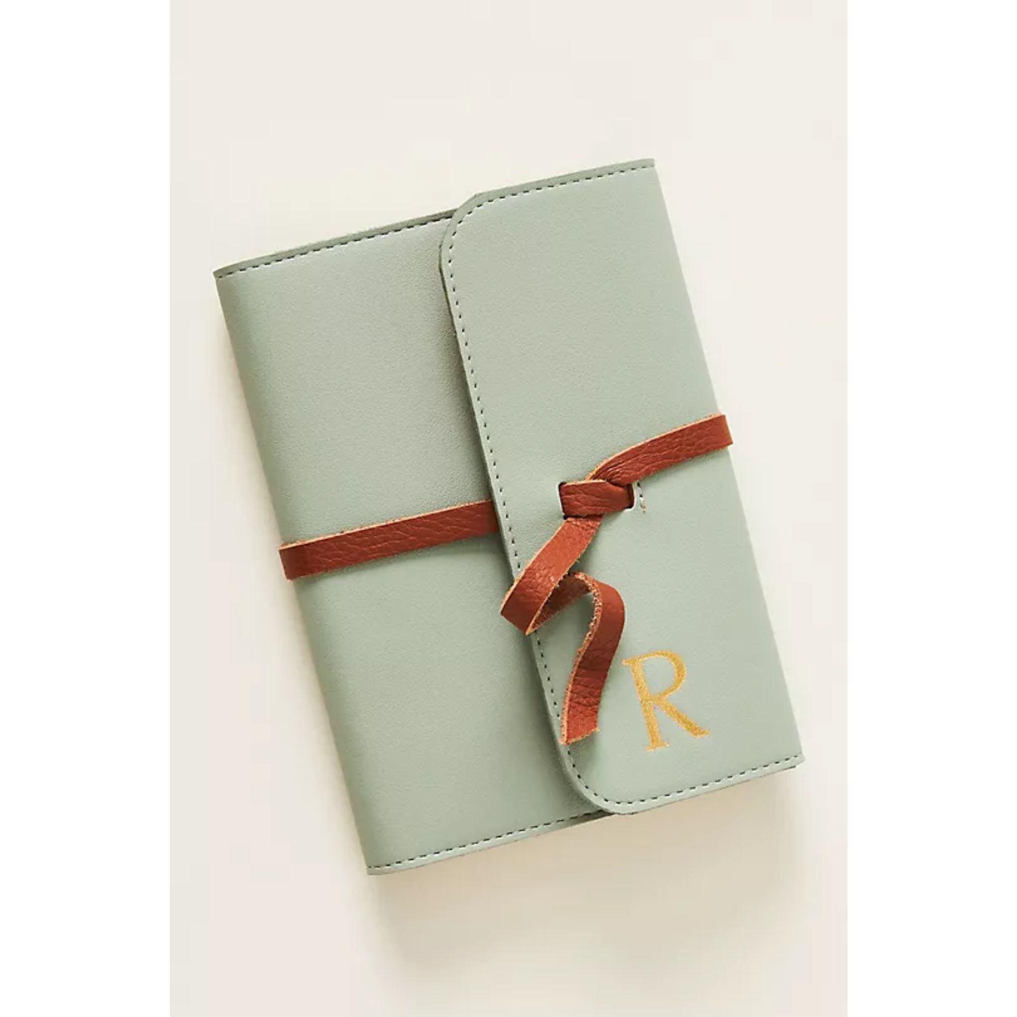 A blue leather notebook with an debossed gold R on the cover