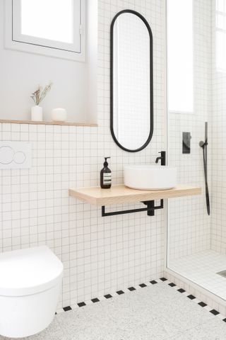 A small bathroom with white subway tiles