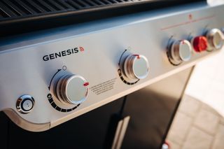 A close up of the knobs on a gas grill