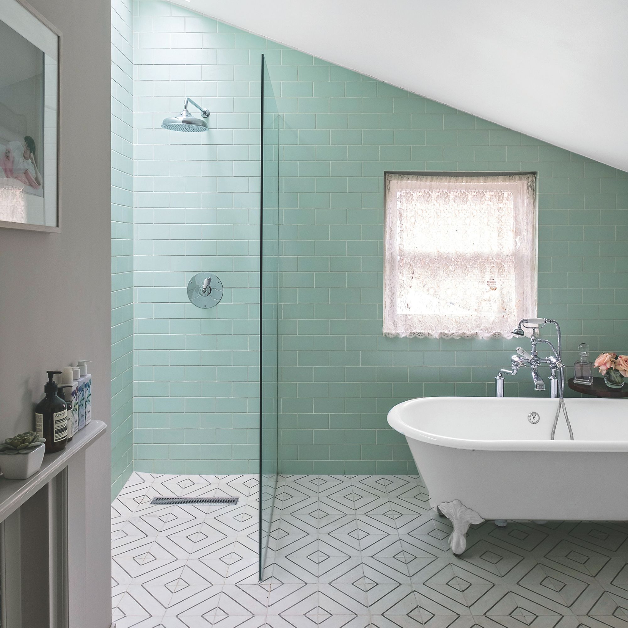 bathroom with white tiled floor and green tiles on the walls. There's a separate shower cubicle and freestanding bath