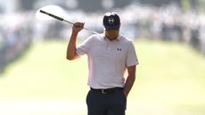 Jordan Spieth walks with his putter over his back