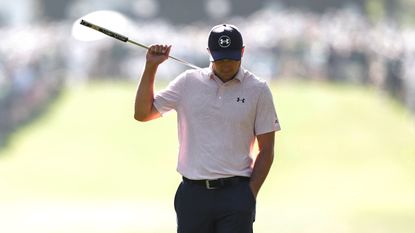 Jordan Spieth walks with his putter over his back