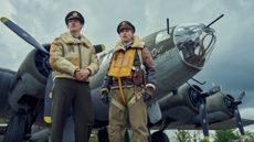 Callum Turner and Austin Butler in Masters of the Air, standng by a plane wearing pilots' uniform