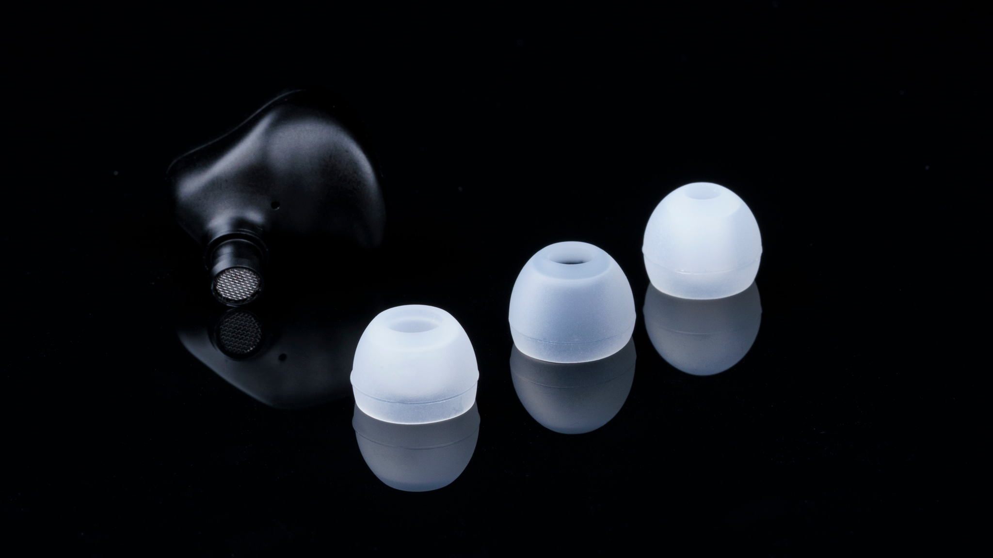 Promotional image of the Fosi Audio IM4 IEMs on a black background showing the three different kinds of ear tips provided