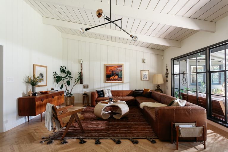 A living room with brown leather sofas