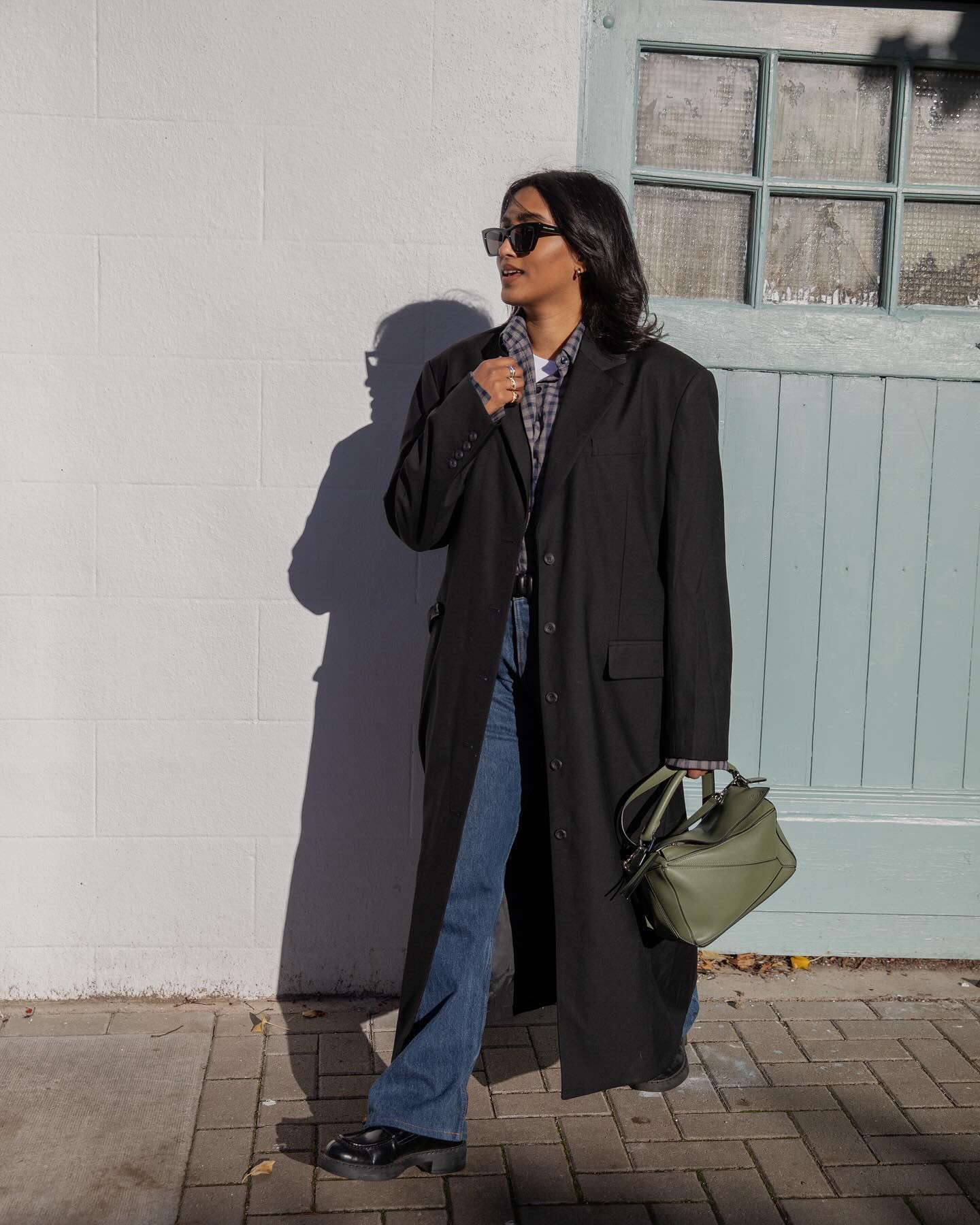 An image of @chiarasatelier wearing a loafers outfit with jeans and a Loewe puzzle bag.