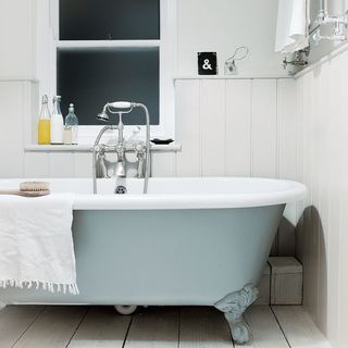 bathroom with white wall and brush on bathtub