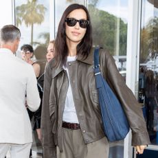 Irina Shayk wears studded flip-flops.