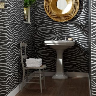 zebra print wallpaper with wash basin and wooden flooring