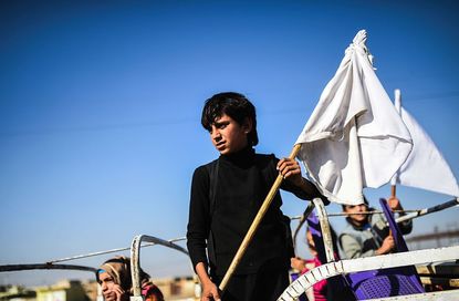 In Iraqi boy fleeing ISIS near Mosul holds a white flag