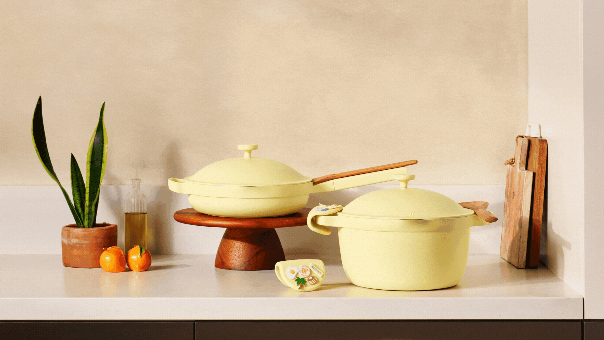 A GIF of yellow cookware and pot holders