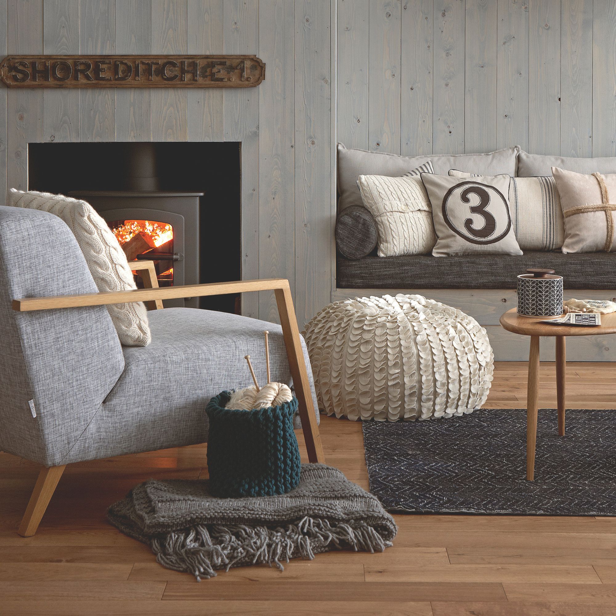 Grey wooden walls with grey seating and layered blankets