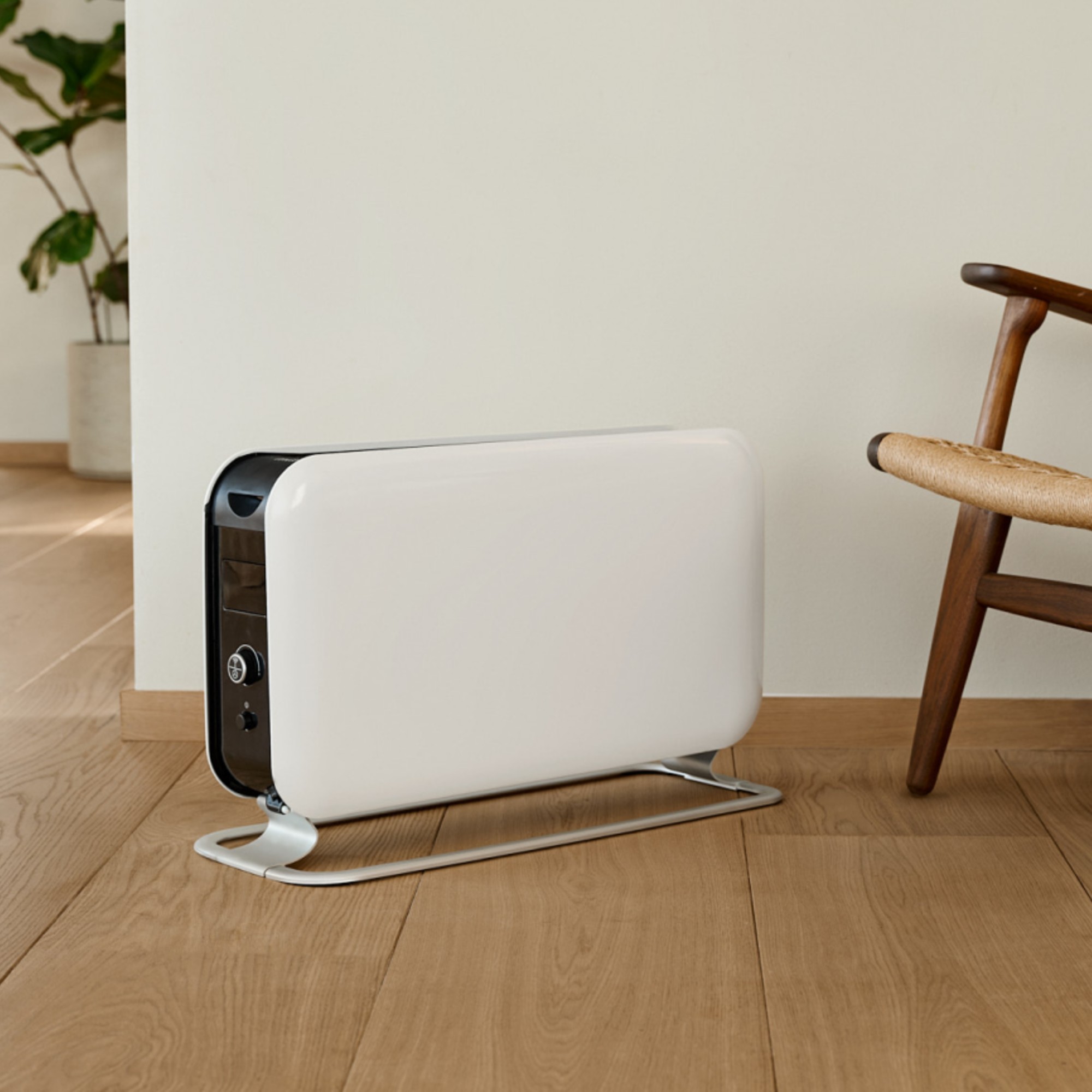 Mill WiFi Max 1500W portable heater standing on the floor next to a wooden chair
