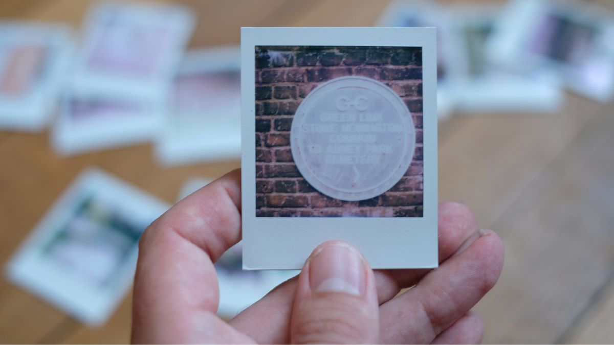 Photograph of prints made with Polaroid Go Gen 3 showing a metal sign attached to a wall