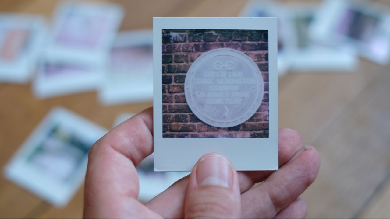 Photograph of prints made with Polaroid Go Gen 3 showing a metal sign attached to a wall