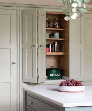 Sage cabinets, blue kitchen island