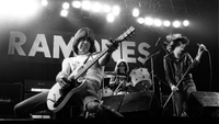 Johnny Ramone and Joey Ramone and Tommy Ramone playing live on stage