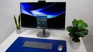 HP OmniStudio X 31.5 all-in-one PC resting on a desk in between house plants