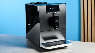 the jura ena 4 automatic coffee machine in piano black with a faceted water tank and bright screen