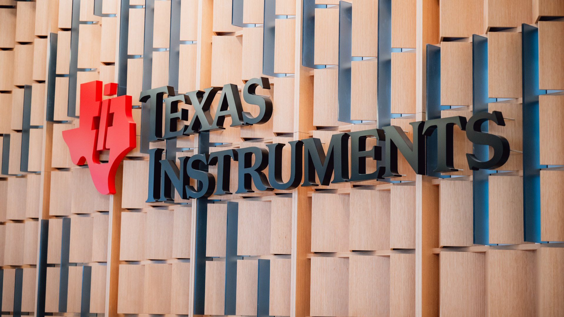 Signage at the Texas Instruments (TI) semiconductor wafer plant in Sherman, Texas, US, on Wednesday, Dec. 17, 2025. Texas Instruments Inc. plans to spend more than $60 billion on semiconductor plants in the US, as the Trump administration urges investments and threatens to upend the sector with tariffs.