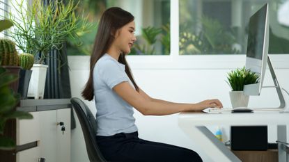 Best posture correctors: Image shows woman sitting upright at desk