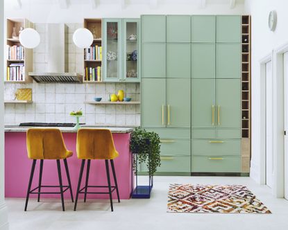 Colourful kitchen with mint green cabinets and pink kitchen island