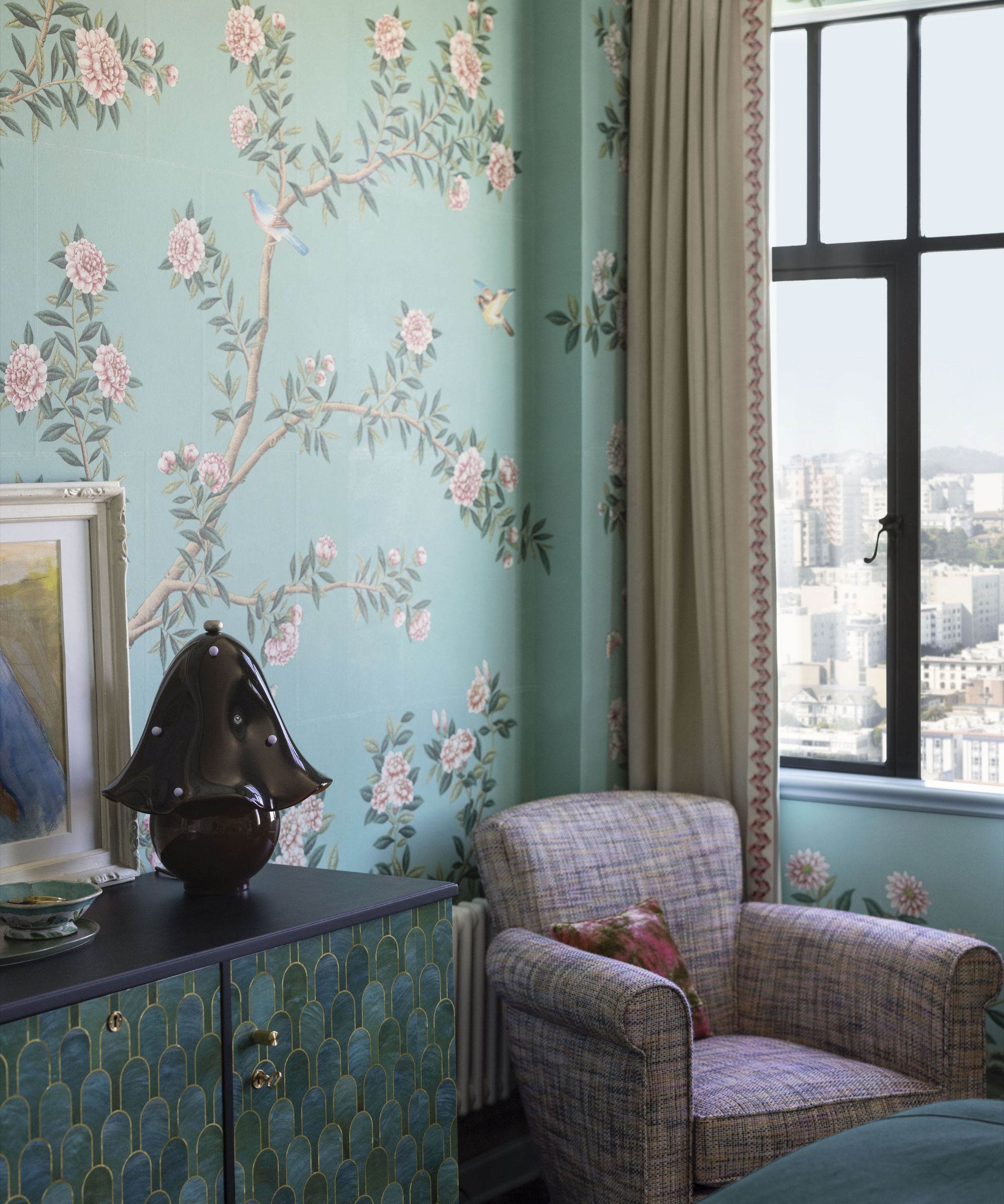 Corner of a blue bedroom with an armchair