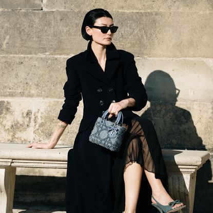 woman holding a bag on a concrete bench