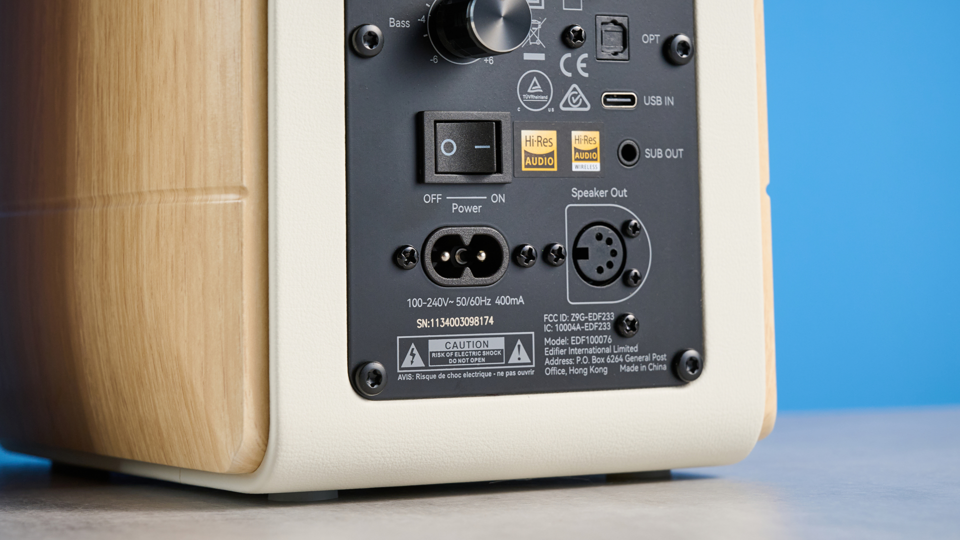 the edifier s880db mkii speakers in white and wood colorway showing the connectivity options, remote control, against a blue background