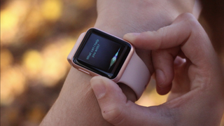 An Apple Watch with Gold casing on someone's arm, as they press the digital crown