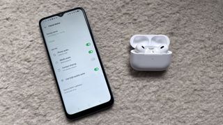 An Android phone with AirPods next to it.