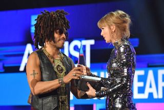Taylor Swift accepts Artist of the Year onstage with Lenny Kravitz during the 2018 American Music Awards at Microsoft Theater on October 9, 2018 in Los Angeles, California