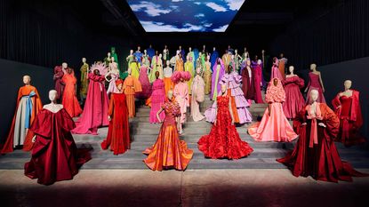 Mannequins on steps in Forever Valentino exhibition in colourful outfits