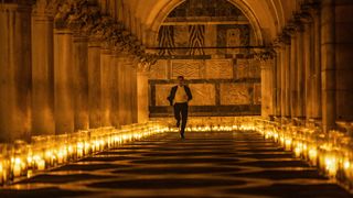Ethan Hunt runs through a candle lit underground passage in Mission Impossible 7