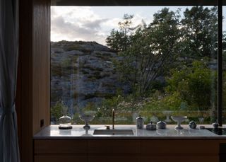 Cabin Lillesand, a norwegian summer house out of wood and its timber interior looking out to waterside nature views through large windows