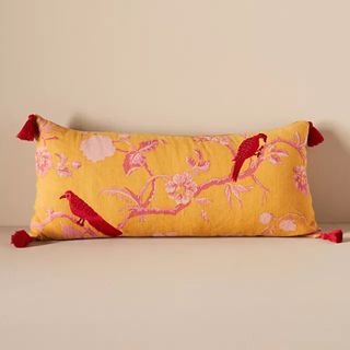 A yellow throw pillow with a flamingo design