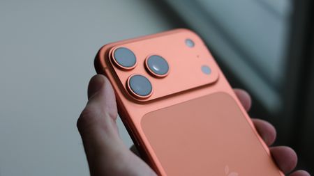 Apple iPhone 17 Pro Max in orange held in a hand