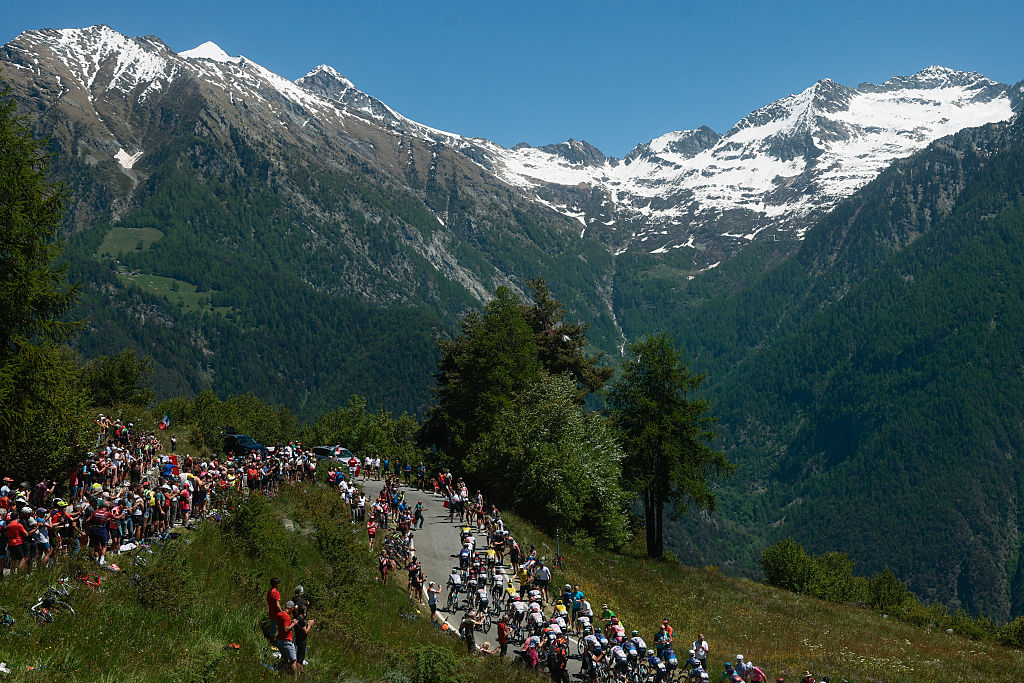 The pack of riders (peloton) cycles in the ascent of Col Tzecore during the 19th stage of the 108th Giro d'Italia cycling race of 166kms from Biella to Champoluc on May 30, 2025. (Photo by Luca Bettini / AFP)