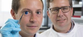 Two of the researchers on the study pose with a 3D-printed cornea