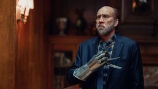 A still from Dream Scenario, showing Nicolas Cage wearing a large bladed gauntlet