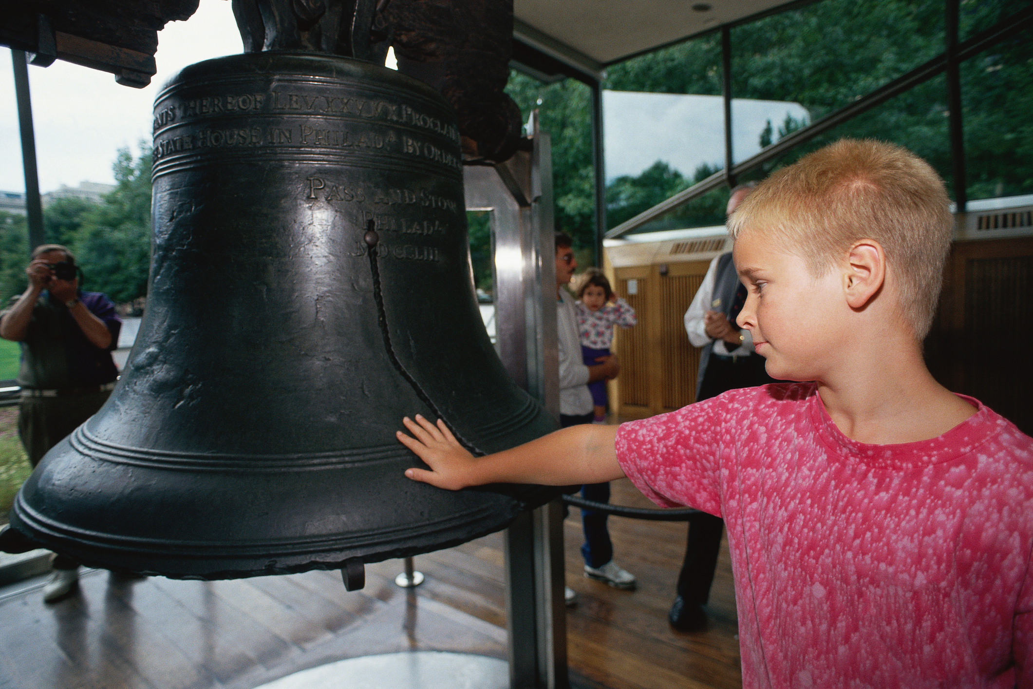 A child reaches out to touch the Liberty Bell.