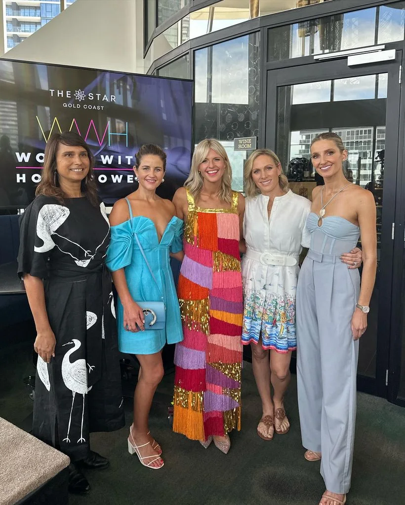 Zara Tindall in a white dress and sandals posing with four women