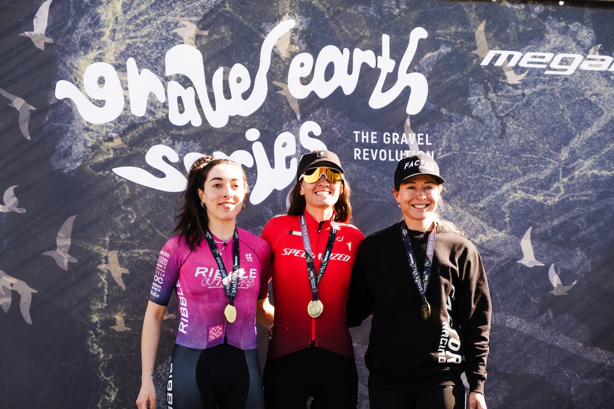 Stage 2 podium of Santa Vall 2026 with Sof&amp;iacute;a G&amp;oacute;mez Villafa&amp;ntilde;e (Specialized Off-road) on the top step, Sophie Wright (Ribble Outliers) in second and Nicole Frain (Factor Racing) third