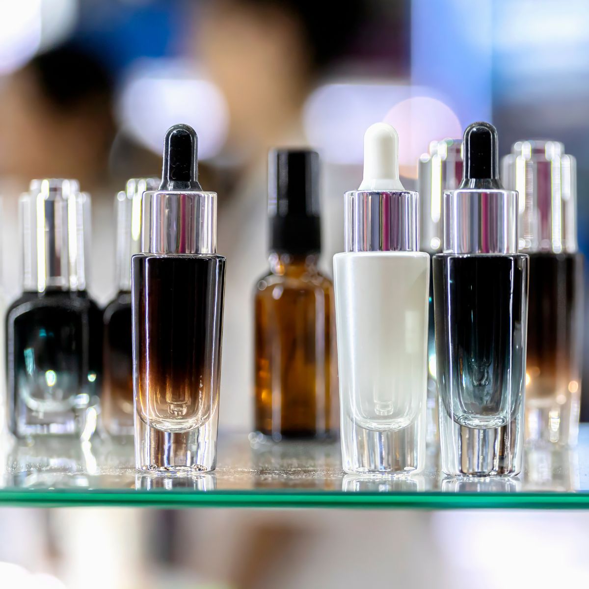 unidentifiable skincare bottles on a glass shelf