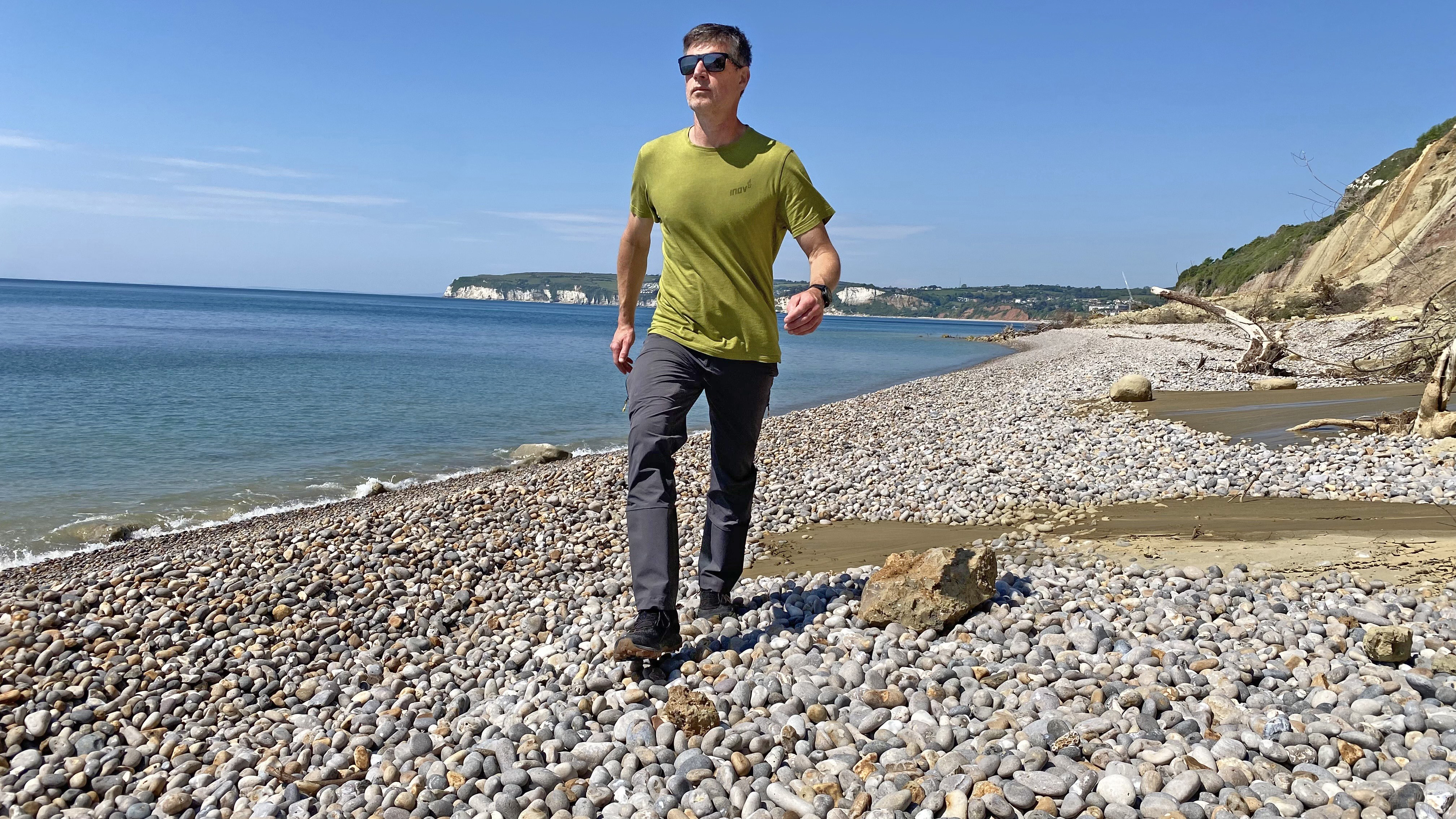 Hiker wearing the Haglofs LIM Flex pants on a pebble beach