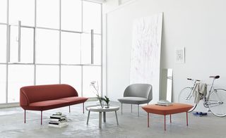 'Oslo' sofa, by Anderssen & Voll for Muuto. A sitting area with an orange sofa, a grey chair, an orange stool and a round grey coffee table.