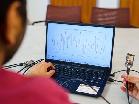 Scientist with a laptop testing the Pulse-Fi technology