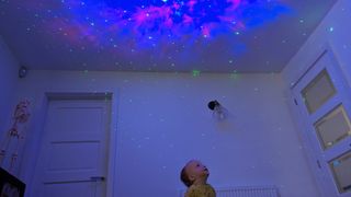Baby enjoying the astronaut starry sky projector nebula patterns - Best star projectors 